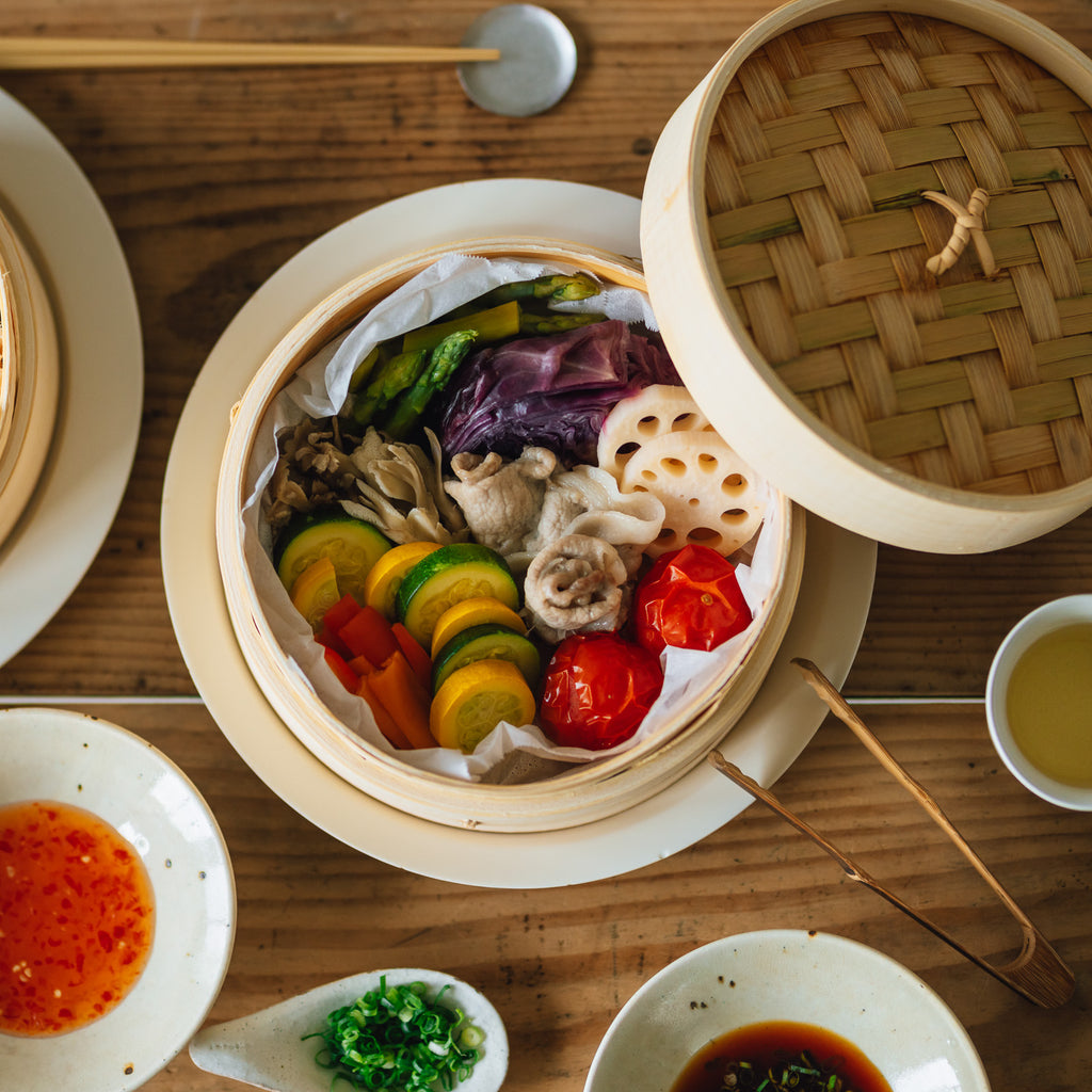 色とりどり、色鮮やかな野菜やお肉を蒸しあげたせいろの様子を俯瞰で撮影した写真。しっとり、つやつやに蒸しあがっている。